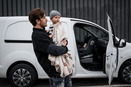 ni&ntilde;o montado en la silla Axkid Minikid Core instalada en una furgoneta